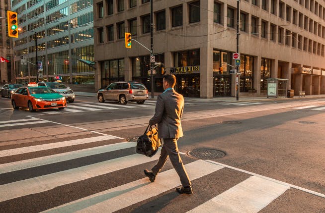 Business man crossing a downtown crosswalk